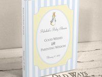 hardcover traditional baby shower guest book the cover has blue and white stripes with yellow accent in a vintage style and features an illustration of Peter Rabbit personalized with mother's name and shower date