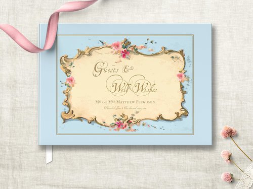 light blue traditional hardcover wedding guest book featuring antique french ephemera frame on the cover with pink floral accent and gold bronze wording personalized with names and wedding date